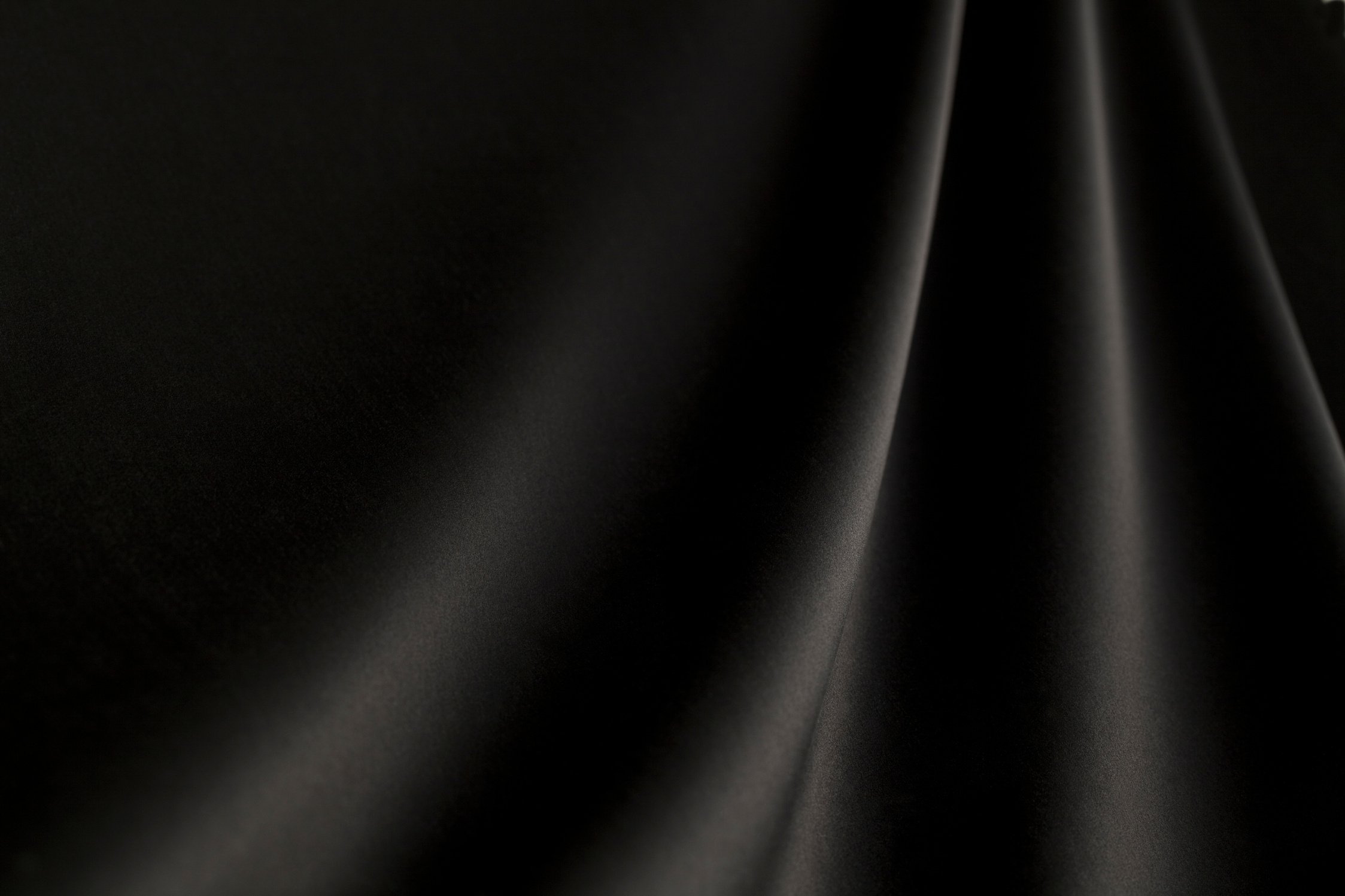 Black silk fabric background with waves